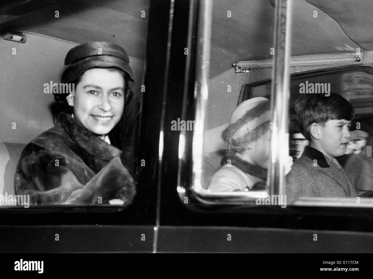 Königin Elizabeth II Reiten in Autos mit Kindern Stockfoto