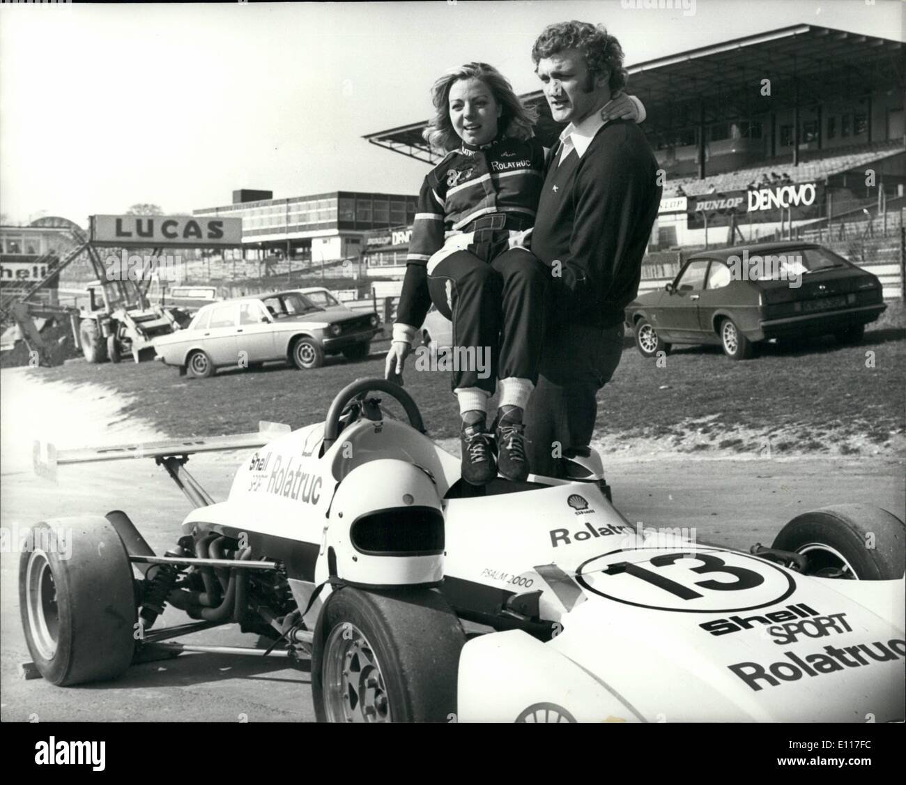 3. März 1976 - Anne Moore und Joe Bugner üben in Brands Hatch: Joe Bugner war unter vielen Olympischen und internationalen Sport-Stars, die heute in Brands Hatch üben für die nächsten Wochen Rennen zugunsten der Langebaan Charity Starks waren. Champion Show Jumper Anne Moore, drehte ihre Hand zum professionellen Motorsport und fahren einen Einsitzer Elden Ford 2000 in etwa 30 Rennen dieser Saison, war es, ein paar Worte zu Joe geben. Foto zeigt Anne Moore in ihr Auto durch Joe Bugner geholfen ist. Stockfoto