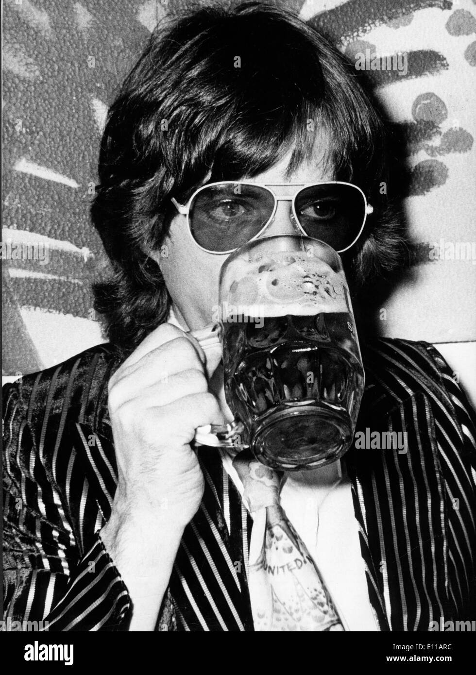 Rolling Stones-Sänger Mick Jagger trinkt ein Bier Stockfoto