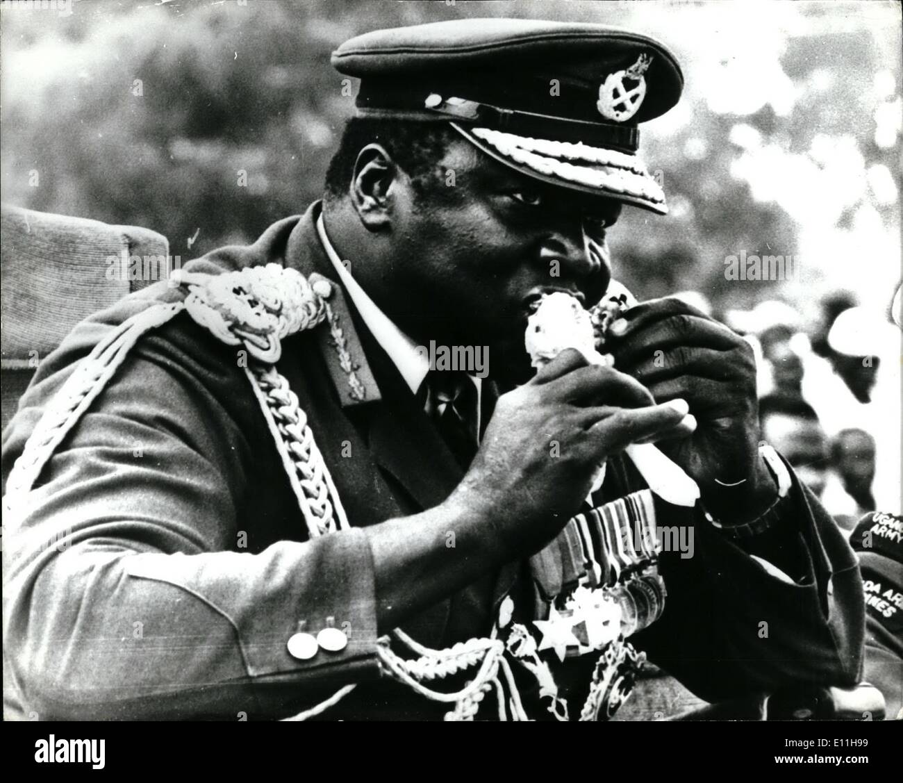 1. Januar 1978 - großen Bissen von Big Daddy: während der Feierlichkeiten zum 7. Jahrestag seiner Militärputsch. Leben Präsident Idi Amin, YC, DSo, MC, Eroberer des britischen Reiches und Oberbefehlshaber der Streitkräfte nimmt einen großen Bissen an ein gebratenes Huhn beim Betrachten der Parade in Koboko Uganda. Stockfoto