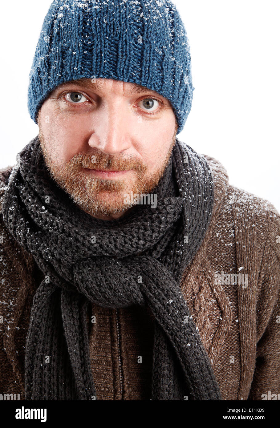 Porträt eines attraktiven Mannes mit blauen Hut im Schnee Stockfoto