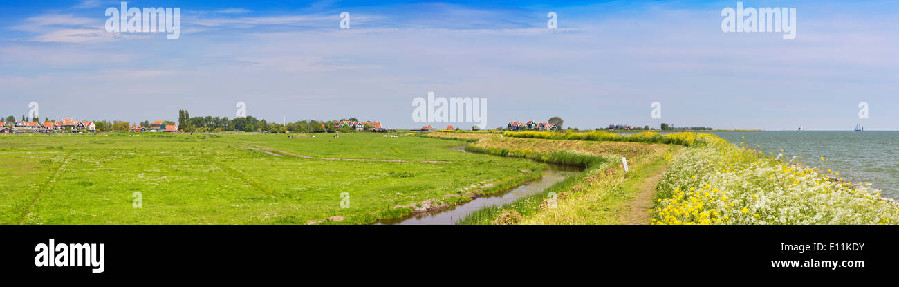 Ein Deich durch typische holländische Landschaft an einem hellen, sonnigen Tag im Frühling Stockfoto