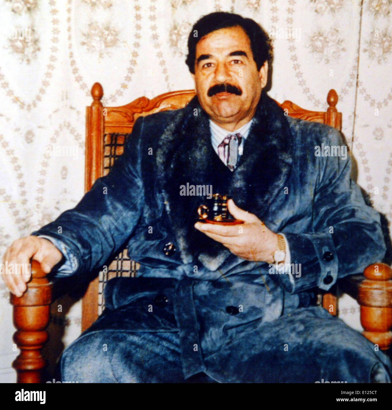 Dann irakischen Präsidenten SADDAM HUSSEIN trägt einen blauen samt Bademantel und hält eine Teetasse Stockfoto