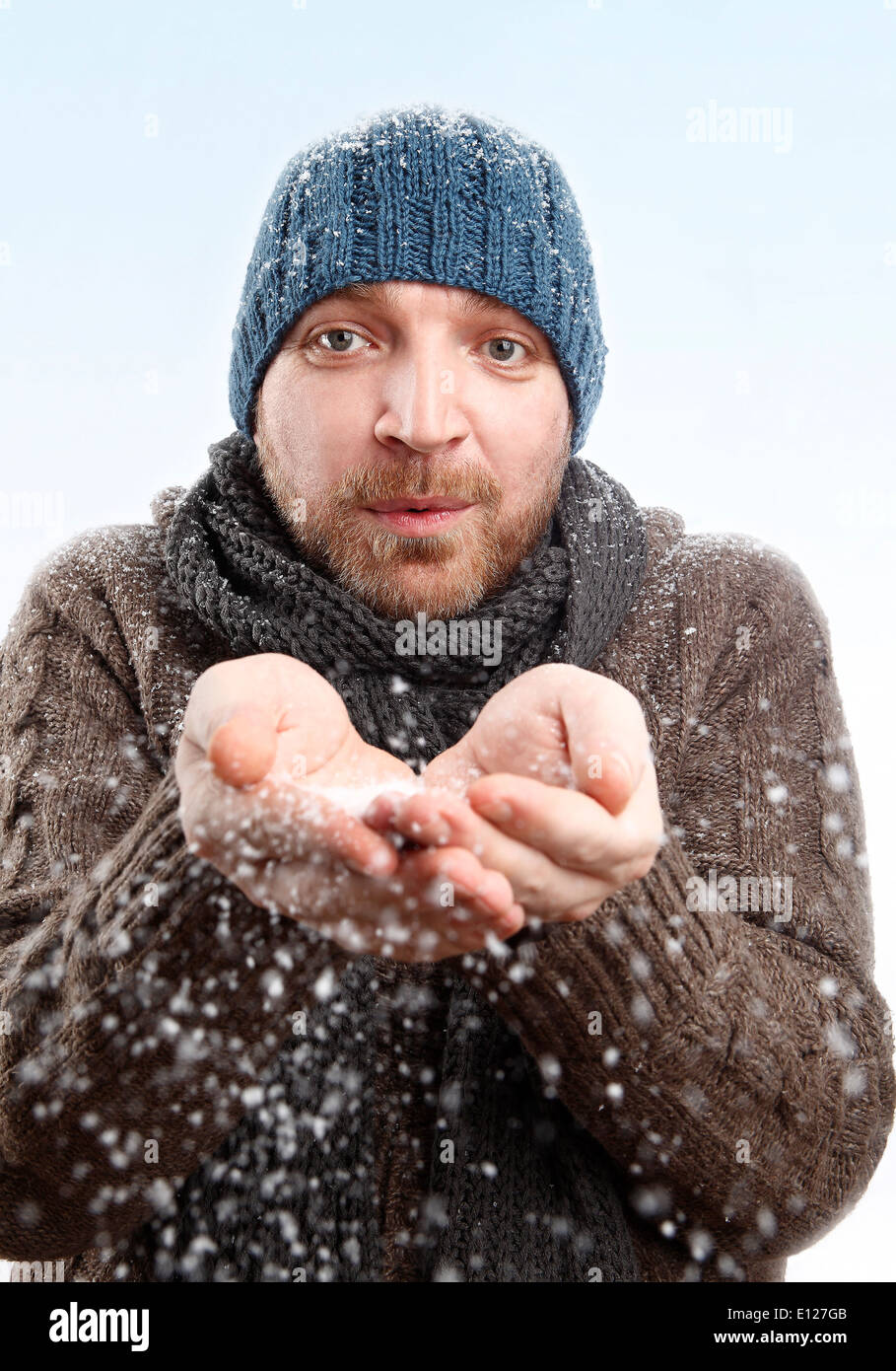 Porträt eines attraktiven Mannes mit blauen Hut im Schnee Stockfoto