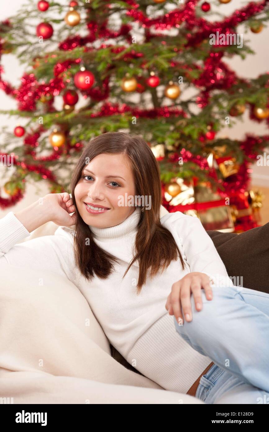 3. Oktober 2009 - 3. Oktober 2009 - lächelnde junge Frau vor Weihnachtsbaum sitzen Cr Stockfoto