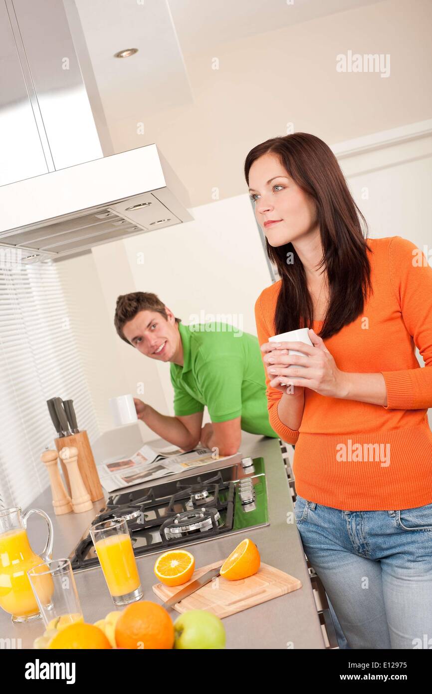 20. Oktober 2009 - 20. Oktober 2009 - junge Frau mit Kaffee in der Küche, Mann im Hintergrund o Stockfoto