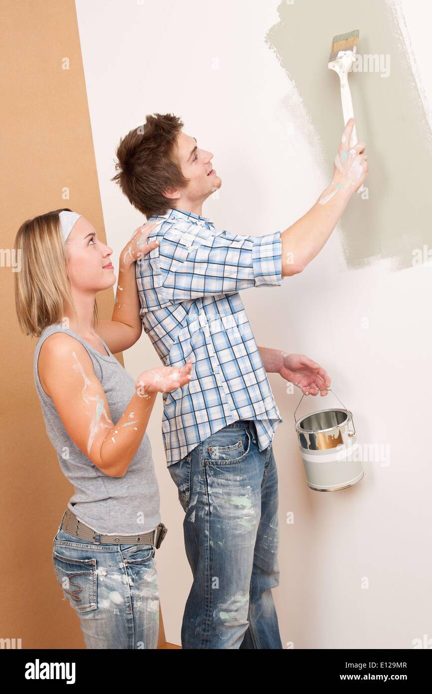 3. Dezember 2009 - 3. Dezember 2009 - Home Improvement: Mann Malerei Wand mit Pinsel Farbe halten kann Stockfoto