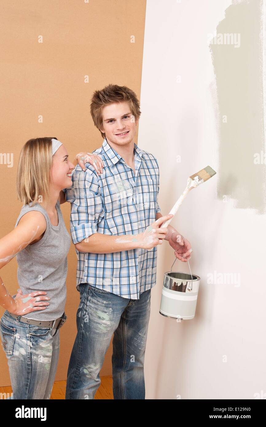 3. Dezember 2009 - 3. Dezember 2009 - Home Improvement: Mann Malerei Wand mit Pinsel Farbe halten kann Stockfoto
