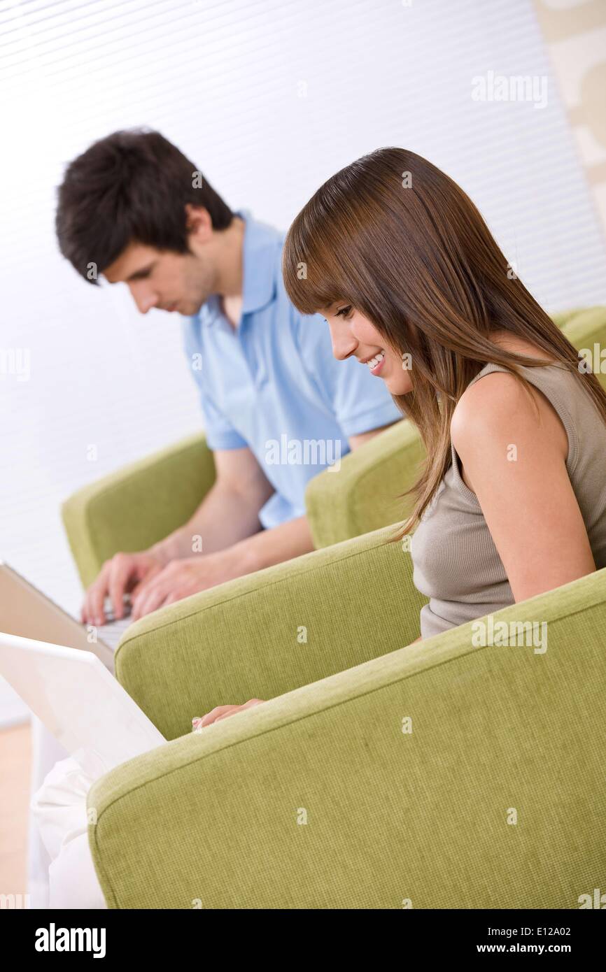 17. April 2010 - 17. April 2010 - Student - zwei Teenager mit Laptop im Wohnzimmer, auf grünen Sessel Stockfoto