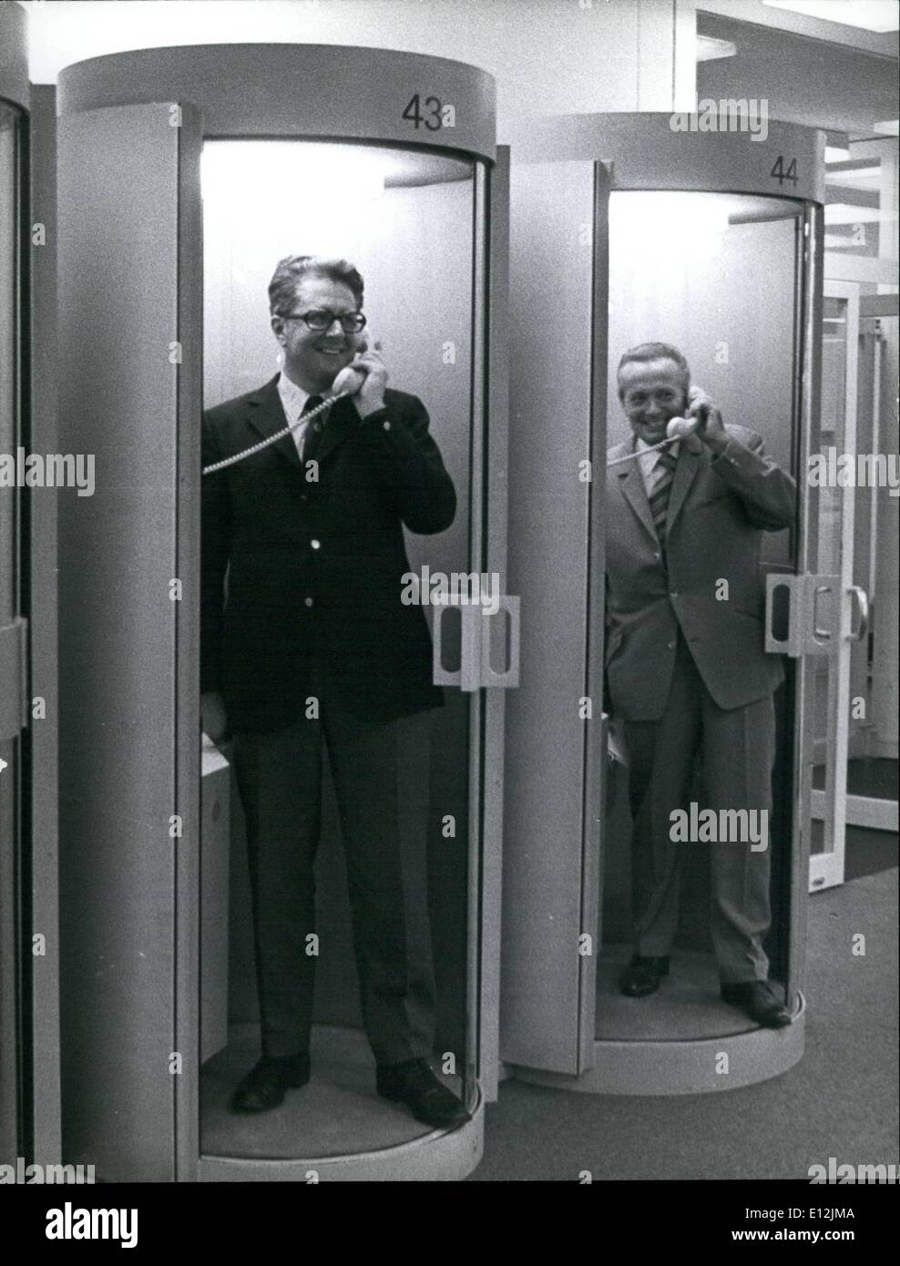 24. Februar 2012 - offizielle Eröffnung des Presse-Centers in München die Olympischen Stätten. Zwei Beamte werden immer ein offenes Ohr. Ehemaliger Oberbürgermeister von München, Hans Jochen Vogel (links) und Präsident des nationalen Olympischen Komitees, Willi Daume, die beiden Männer, die die Olympischen Spiele nach München gebracht getestet die neuen modernen Telefonkabinen anlässlich der Eröffnung des Presse-Centers an die Olympischen Stätten Stockfoto