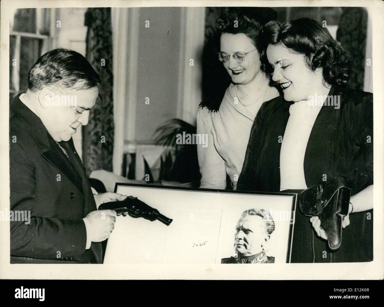 24. Februar 2012 - sendet Marshall Tito seine Waffe an New Yorker Bürgermeister Fiorello H.Laguardia, Bürgermeister von New York City, Examines eine Pistole von Marschall Tito, Kommandant der jugoslawischen Armee der Befreiung zu ihm geschickt. Mit der Waffe die der Marschall in seiner Kampagne zu fahren die deutschen aus Jugoslawien eingesetzt, war eine Brief und ein Foto des Spenders. Zwei Mitglieder des Ausschusses Vereinten slawischen Südamerikaner, vermisst Charlotte Mugan und Ann Traven, überreichte die Geschenke an Bürgermeister Laguardia. Stockfoto