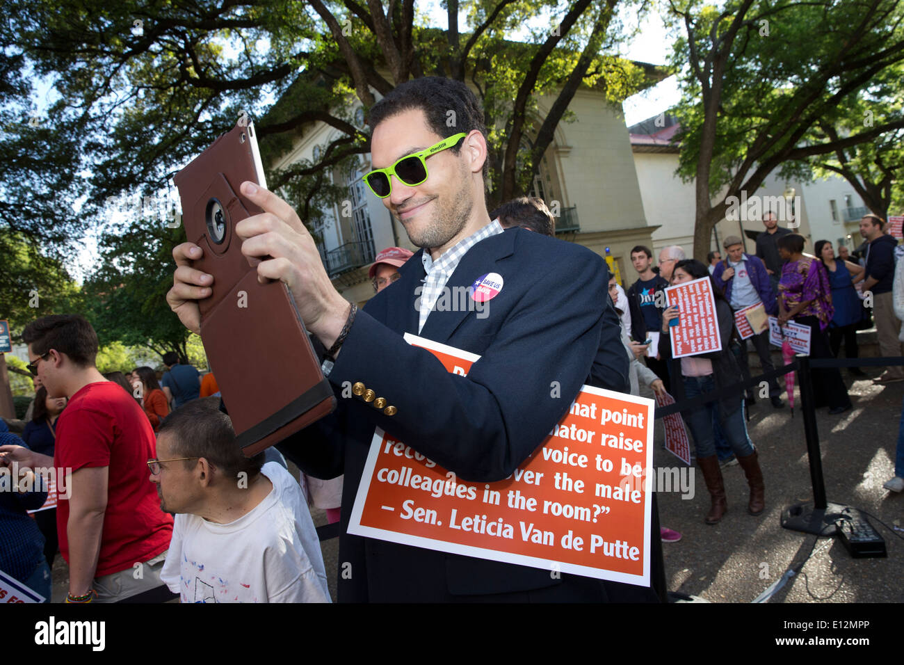 Männliche College-Student nimmt Foto mit seinem Tablettcomputer während einer demokratischen Kampagne Kundgebung auf dem Campus der University of Texas Stockfoto