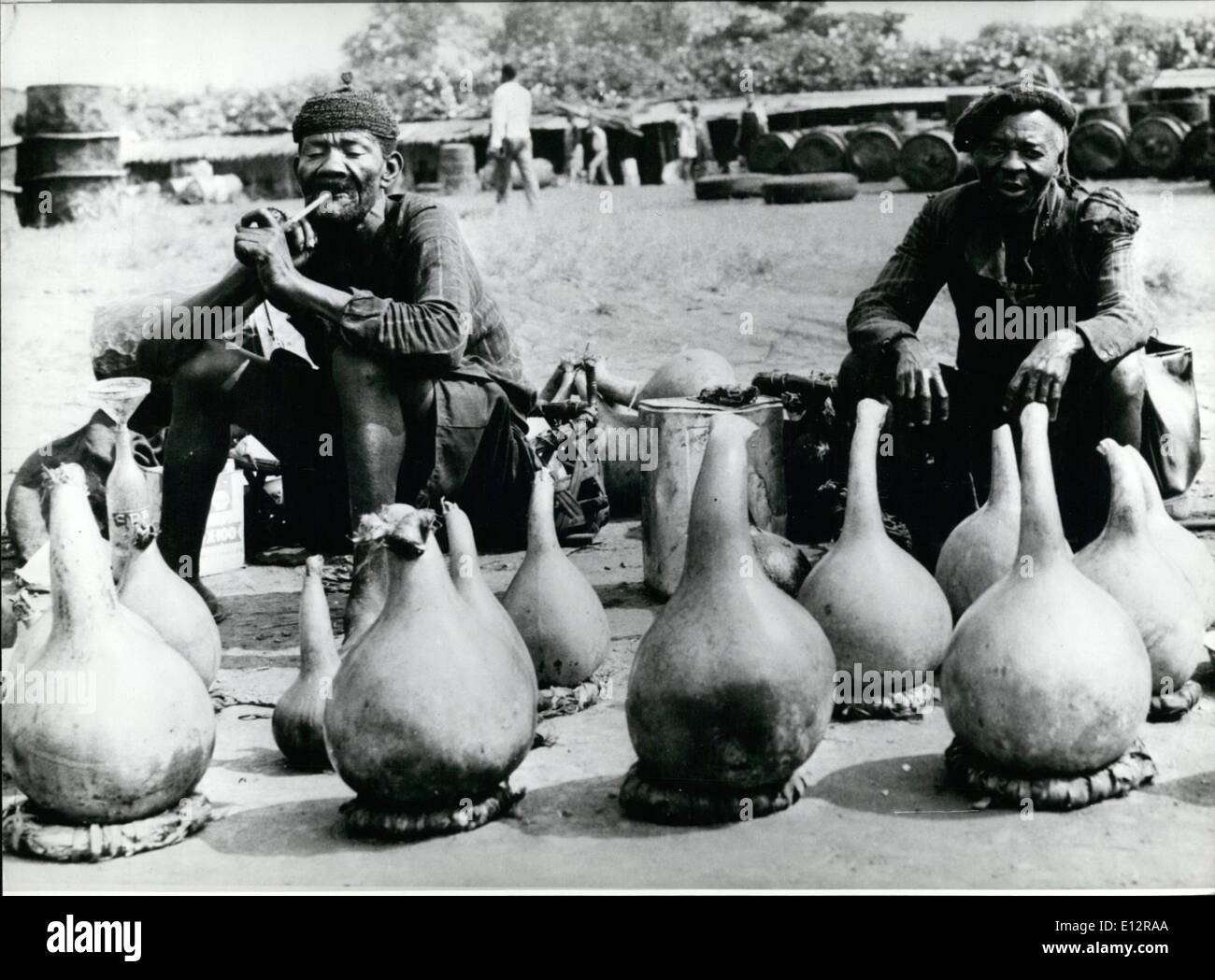 24. Februar 2012 - nehmen Sie es einfach: diese beiden Wein-Anbietern auf dem Markt von Bafoussam / Kamerun warten geduldig für einen Kunden zu kommen und einige ihrer '' Tari'' (Palmwine), einer von ihnen offenbar genießt den Rauch seiner Pfeife zu kaufen. Stockfoto