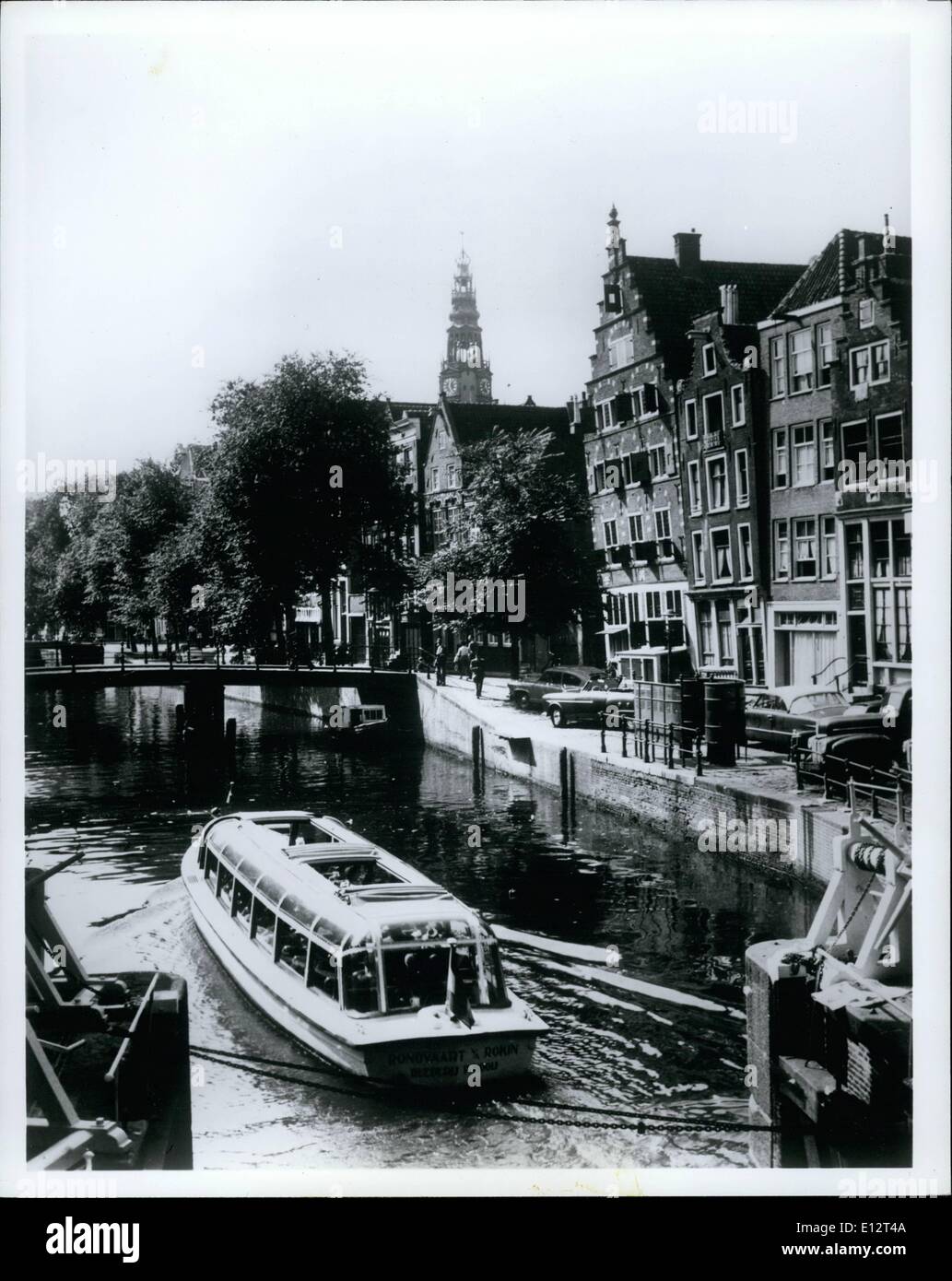 25. Februar 2012 - der schiefe Häuser von Amsterdam: die allgegenwärtige Kanalboot durchläuft eine Sperre im Kanalsystem Amsterdams als Stockfoto