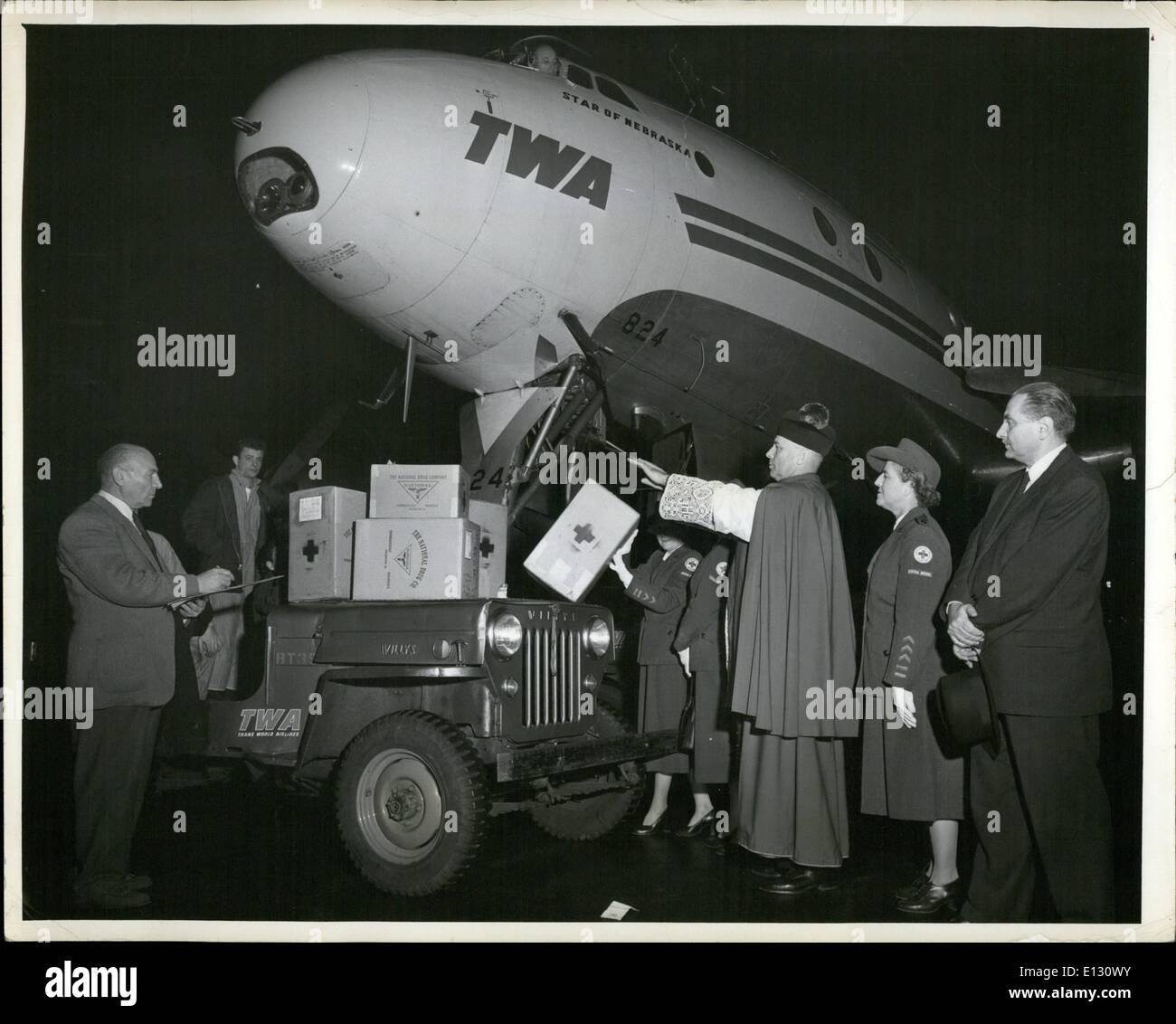 26. Februar 2012 - Flughafen Idlewild, NJ/ - Okt.28 - Medizinische Versorgung für Opfer von antirussischen Unruhen in ungarn wird von Monsignore Bela Varga, Präsident des Ungarischen Nationalrats, gesegnet. Vor der Verladung an Bord eines ans Welt-Airliner internationale Konstellation für die Schweiz gebunden ist die Sendung die zweite von drei heute zu gehen, um über die  österreichisch-ungarische Grenze verteilt werden auch anwesend sind Mitglied des amerikanischen Roten Kreuzes der Ungarischen Nationalrat. Von links nach rechts: Dr. Alexander Hahn, Schatzmeister des Ungarischen Nationalrats prüft die Liste der Lieferungen, Frau Stockfoto