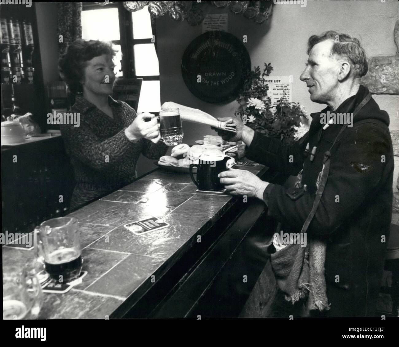 26. Februar 2012 - Allan Haltestellen seiner Stammkneipe und tauscht das Papier für ein Pint mit Wirtin Connie Braithwaite, der Inn in Cadesy in Spwotborough, Yorks. Stockfoto