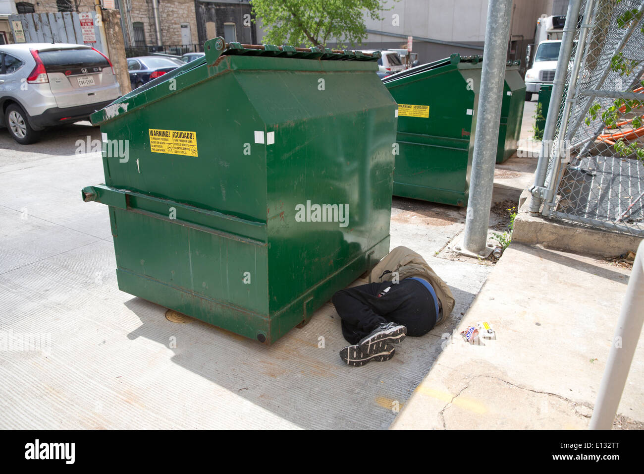 Obdachloser schläft hinter Müllcontainer in der Innenstadt von Austin Texas Stockfoto