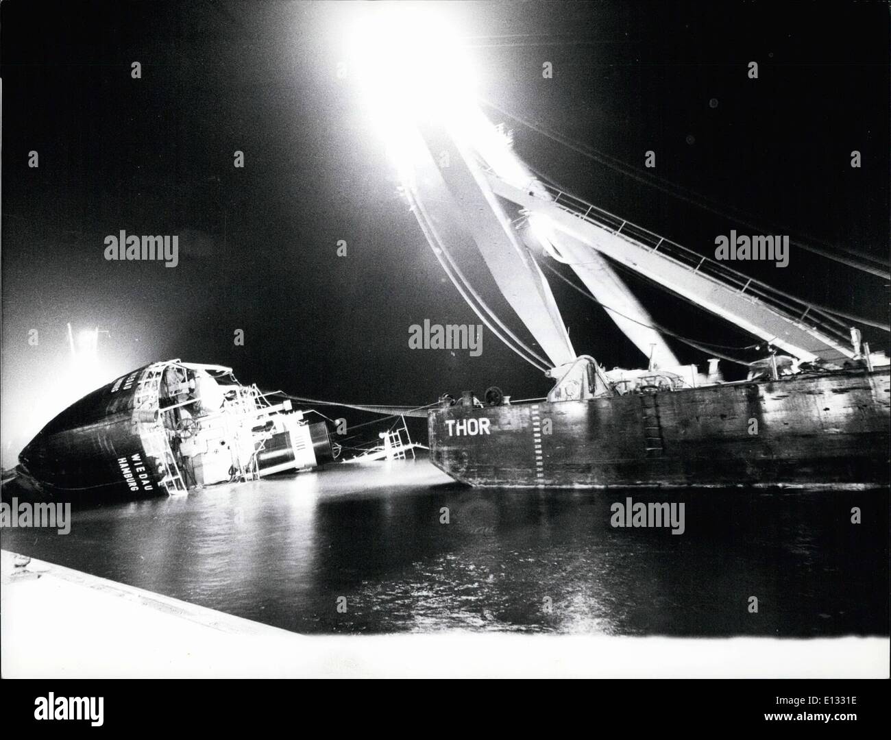 26. Februar 2012 - Bergung des gekenterten Schiffes '' Wiedau'' in Hamburg--eine gespenstische Szene: hier an der Elbe in Hamburg zu sehen ist. In der linken Seite ist das deutsche Motorschiff '' Wiedau'', die am 19. Dezember 1975 nach einer Kollision mit zwei anderen Schlückchen in einen dichten Nebel versenkt. Jetzt die '' Wiedau'' mit dem Kran Kran '' Thor'' (in der rechten Ecke) gesichert wird, ein Schwimmen-Koloss, der Gewichte heben kann bis zu 1000 Tonnen. Der Kran wurde von einem seefahrenden Schlepper aus Schweden durch die Nord-Ostsee-Meer-Kanal nach Hamburg für diese Bergungsaktion gezogene. Stockfoto