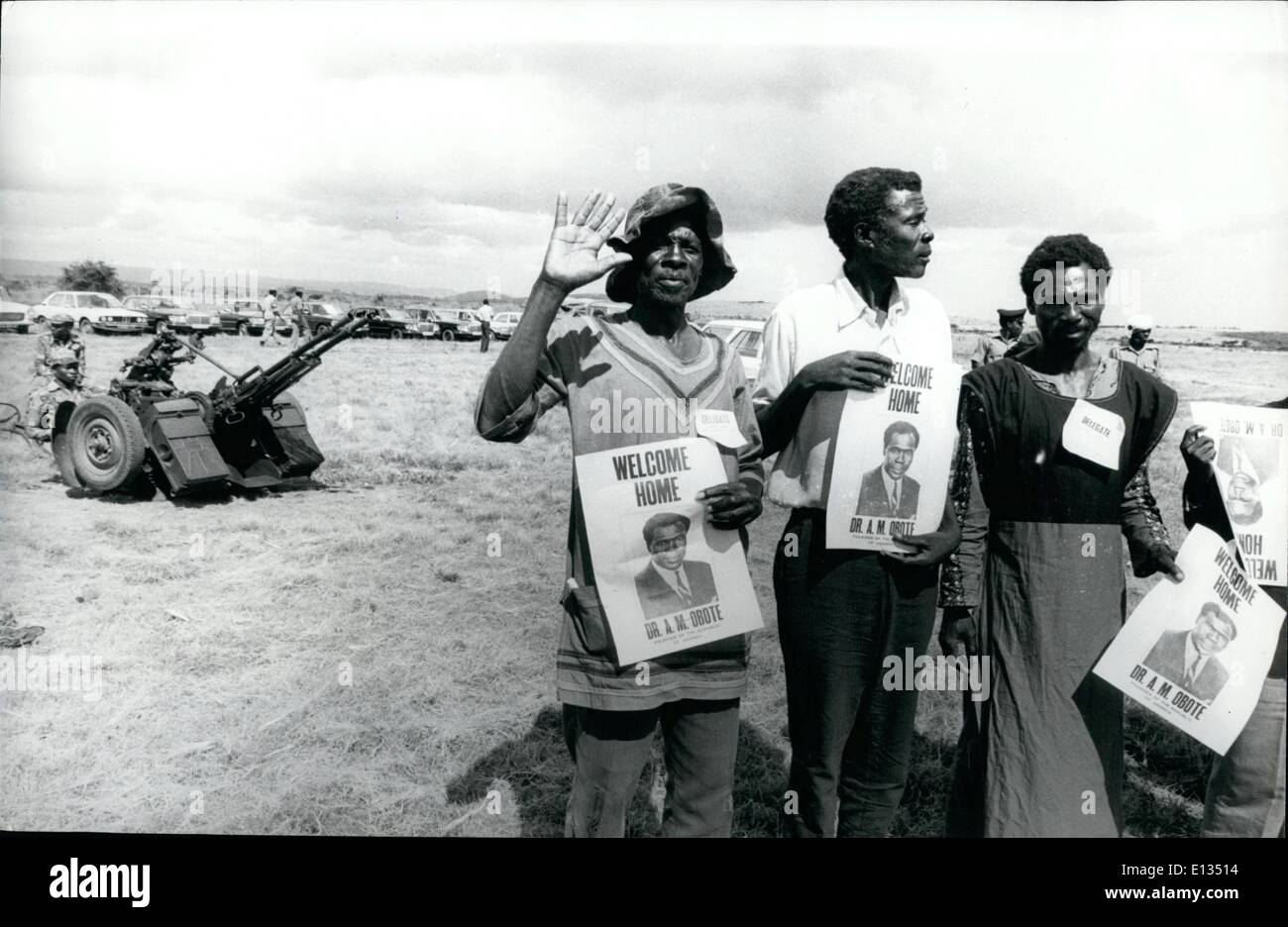 26. Februar 2012 - kehrt Obote in Uganda; Auf Mberera Flugplatz - einige der Obote Verfechter mit welcome home Plakate. Im Hintergrund ist Tansania Flak mit tansanischen Soldaten besetzt. Stockfoto