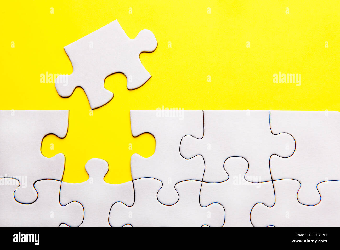 Weiße Puzzleteile fehlt auf gelbem Hintergrund Stockfoto