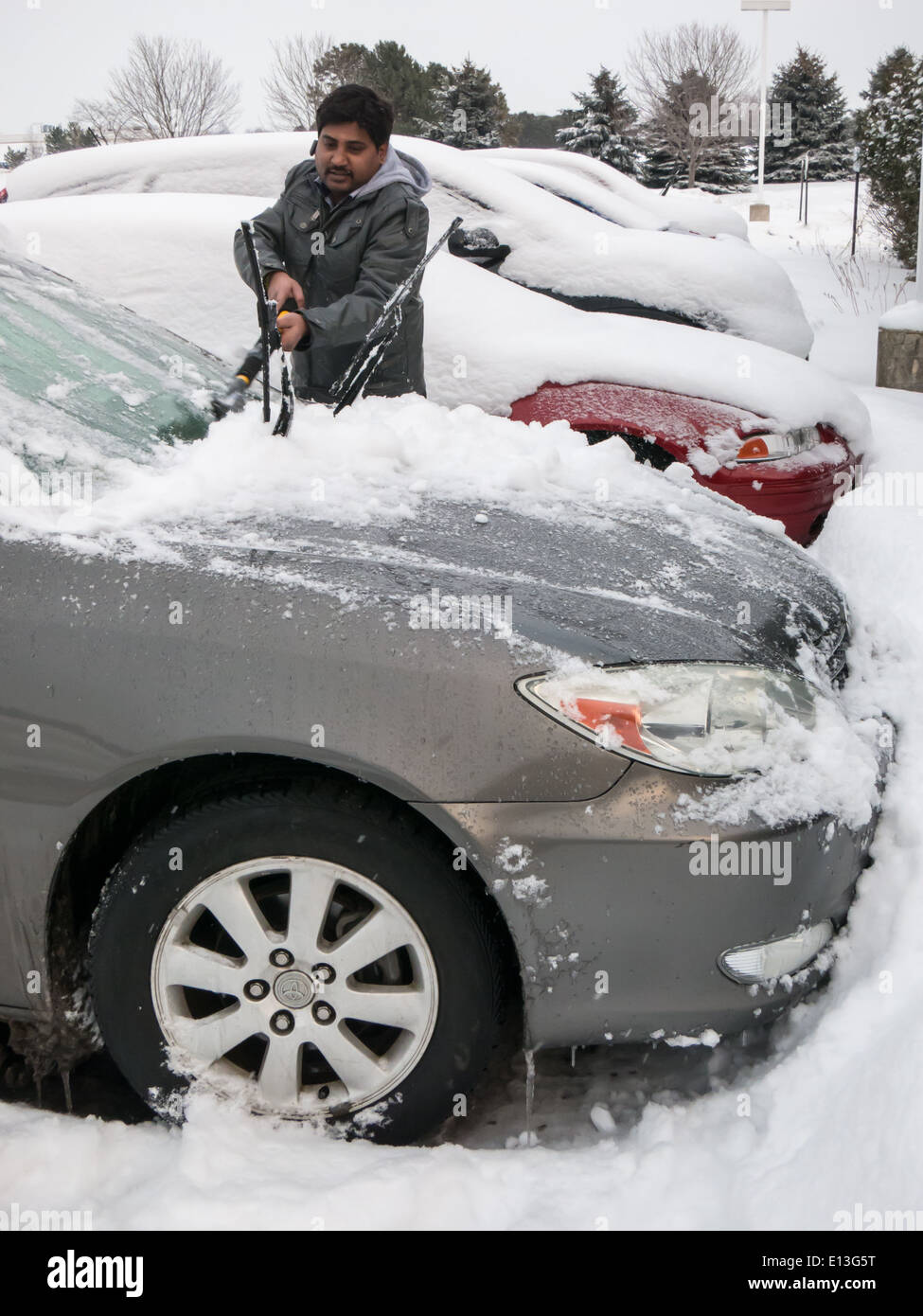 Ein Mann Reinigung Schnee aus dem Auto in Amerika im winter Stockfoto
