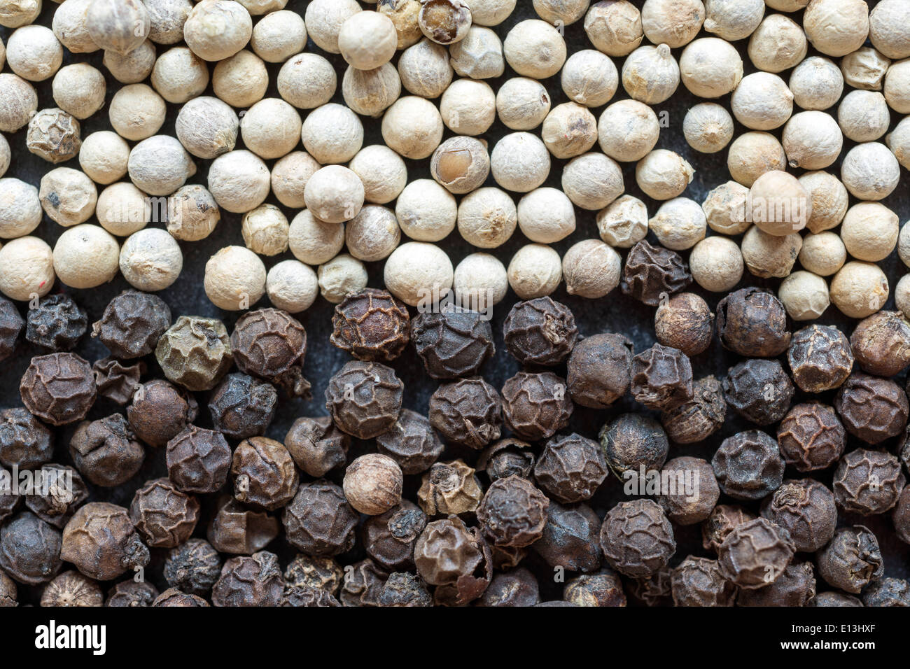schwarze und weiße Pfefferkörner vermischen als Hintergrund Stockfoto