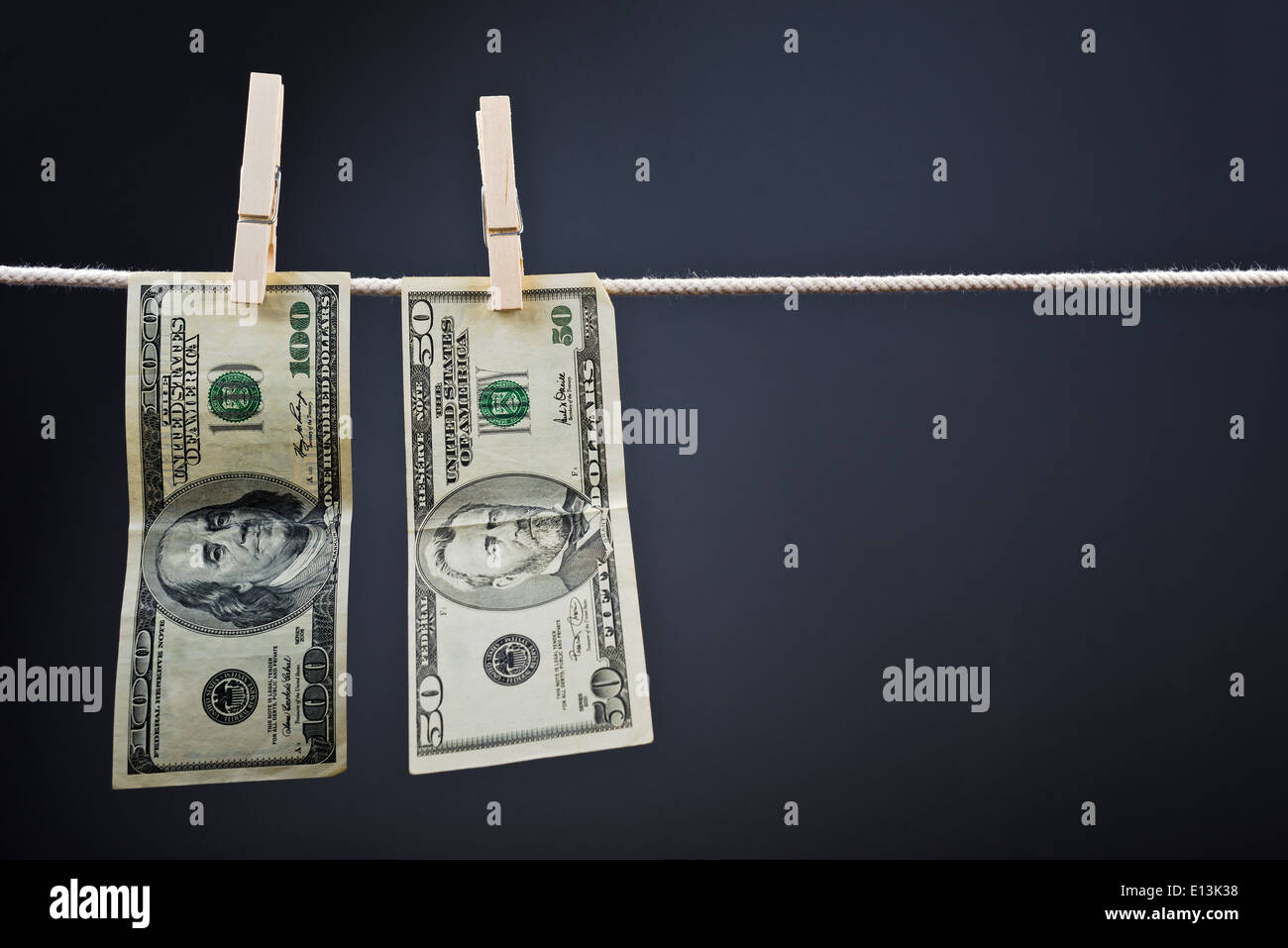 Amerikanische Währung. USA-Geld, Dollarscheine hängen am Seil mit Wäscheklammern befestigt. Stockfoto