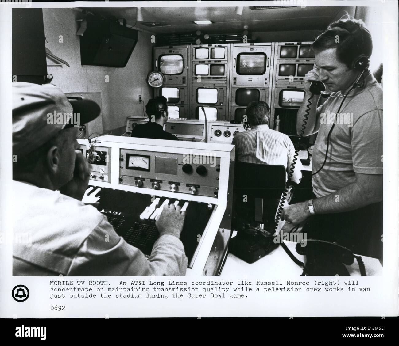 22. März 2012 - Mobile TV Stand. ein Koordinator für die AT&T lange Schlangen wie Russell Monroe, Recht, konzentriert sich auf die Erhaltung der Übertragungsqualität zwar ein Fernsehteam in van nur außerhalb des Stadions während der Super-Bowl-Spiel funktioniert. Stockfoto