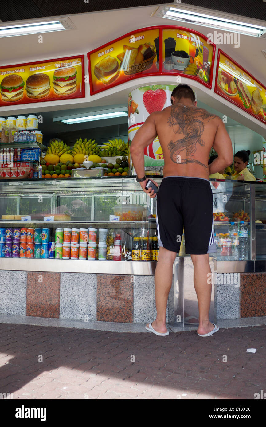 RIO DE JANEIRO, Brasilien - 24. Oktober 2013: Tall brasilianischen Mann mit auffälligen Tattoo steht warten auf typische Saft Stand. Stockfoto