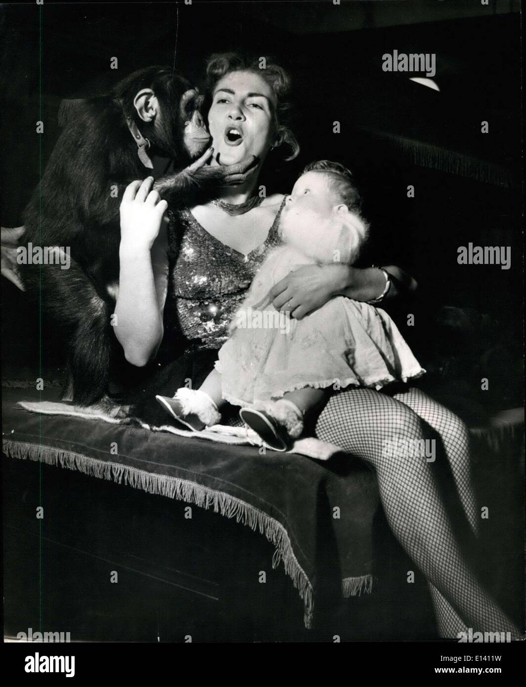 31. März 2012 - Trapezkünstler Margaret Stey Krankenschwestern ihr Baby, 9-Monate-alten Candy während einer Pause bei den Proben für die Big Top wenn entlang kommt Zirkus Schimpanse, Dean und gibt ihr einen großen dicken Kuss. Zirkus '' andere '' Baby sitzt '' auf A Trapez: Es ist immer ein Problem für Mütter mit Jobs zu tun, zu wissen, was Sie mit ihren Babys während der Arbeitszeit zu tun. Mrs Margaret Stey, gewagte Tapeze-Künstler, der in Jack Hyltons Zirkus im Earls Court in diesem Jahr erscheinen soll löst das Problem, indem Sie ihre 9-Monate alten Tochter, Candy, mit ihr, als sie am Trapez hoch über der Sägemehl-Ring praktiziert Stockfoto