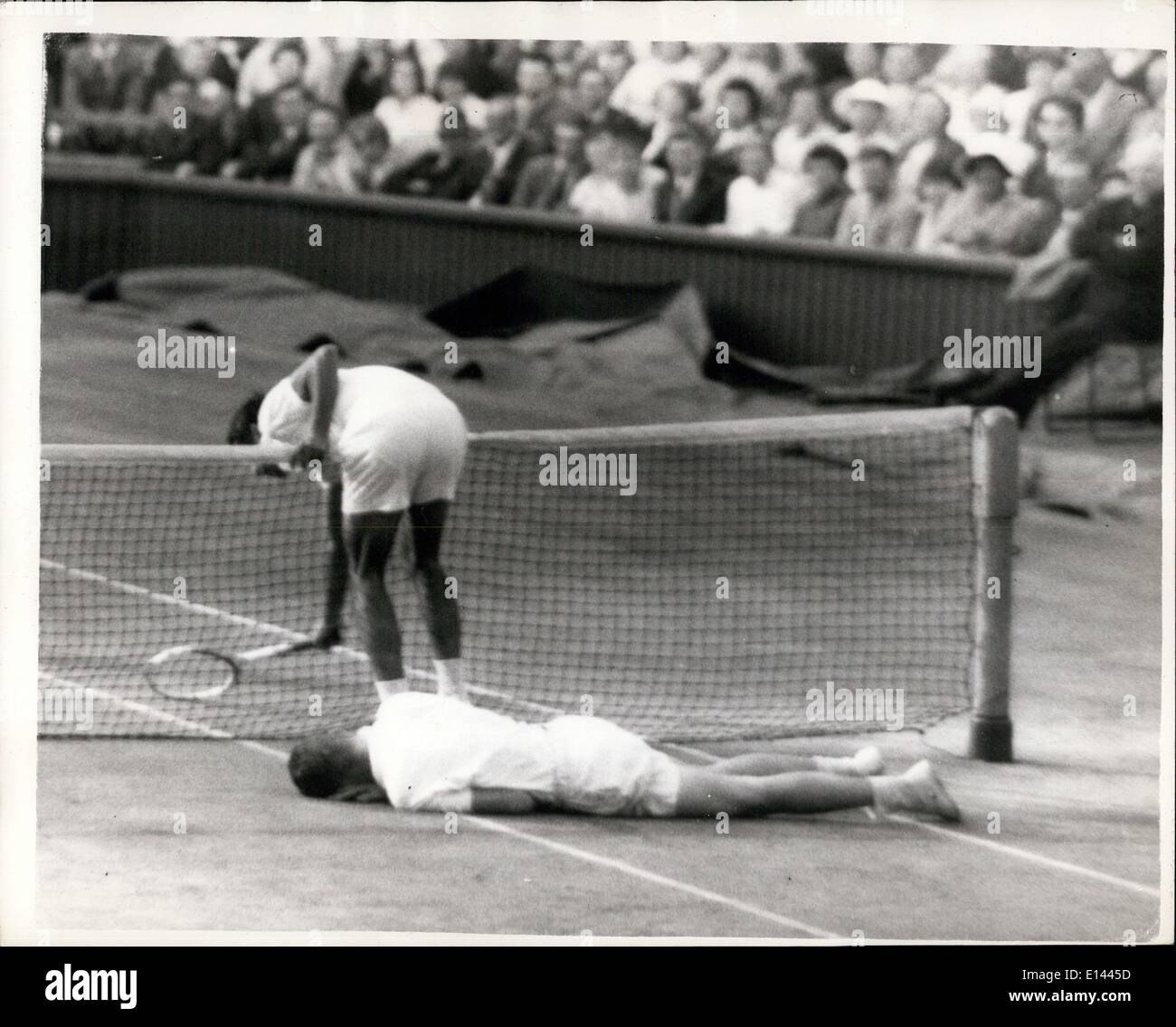 4. April 2012 - Tennis in Wimbledon. Sie sind unten - aber nicht aus. Foto zeigt heute, während ihre Männer-Doppel-Match in Wimbledon hängt beim Versuch, den Ball zu erreichen, R. Osuna (Mexiko) über das Netz nach hinein laufen. während sein Partner? R. Ralston (U.S.A.), liegt nach einem Sturz - während ihr Match gegen R. Laver und R.Mark, beide von Australien, in Wimbledon heute in voller Länge. Osuna und Ralston gewann gegen die mehr eingebildeten australische paar. Stockfoto