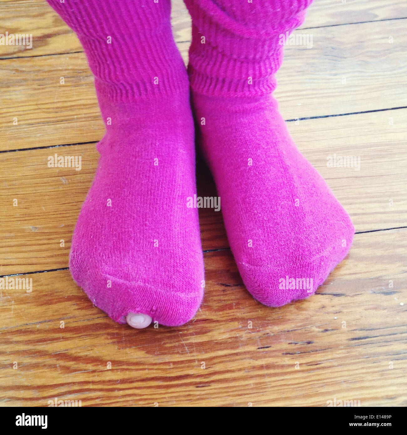 Des Mädchens Zehe spähen aus Loch im Strumpf - Smartphone-aufgenommenes Stockfoto