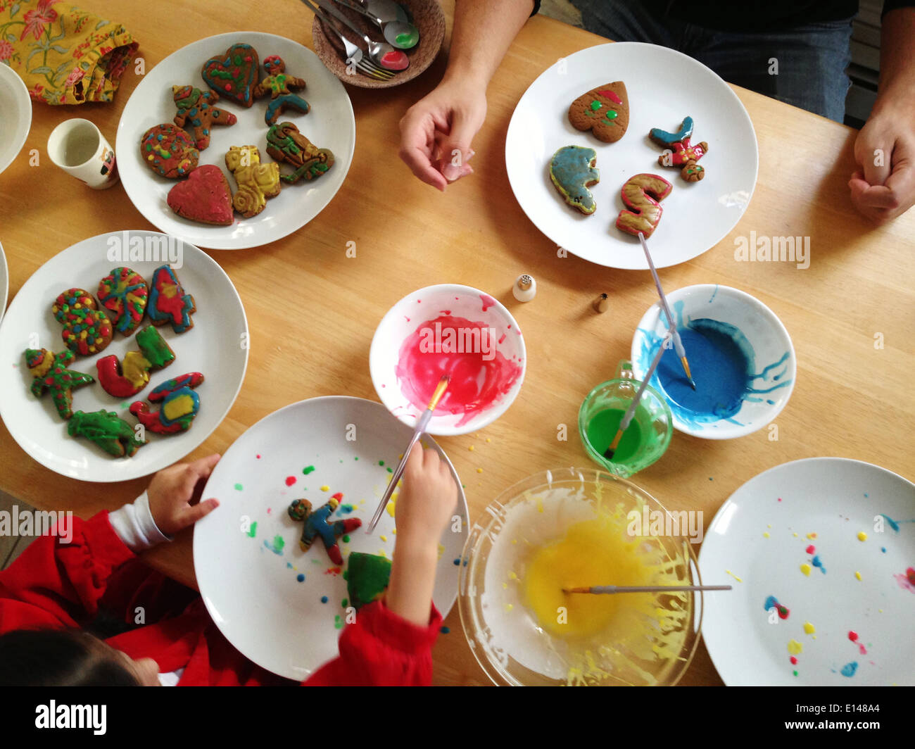 Vater und Tochter decorating Christmas cookies - Smartphone-aufgenommenes Stockfoto