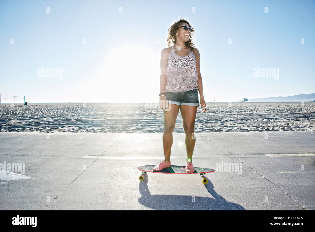 Afroamerikanische Frau Longboard am Strand Reiten Stockfoto