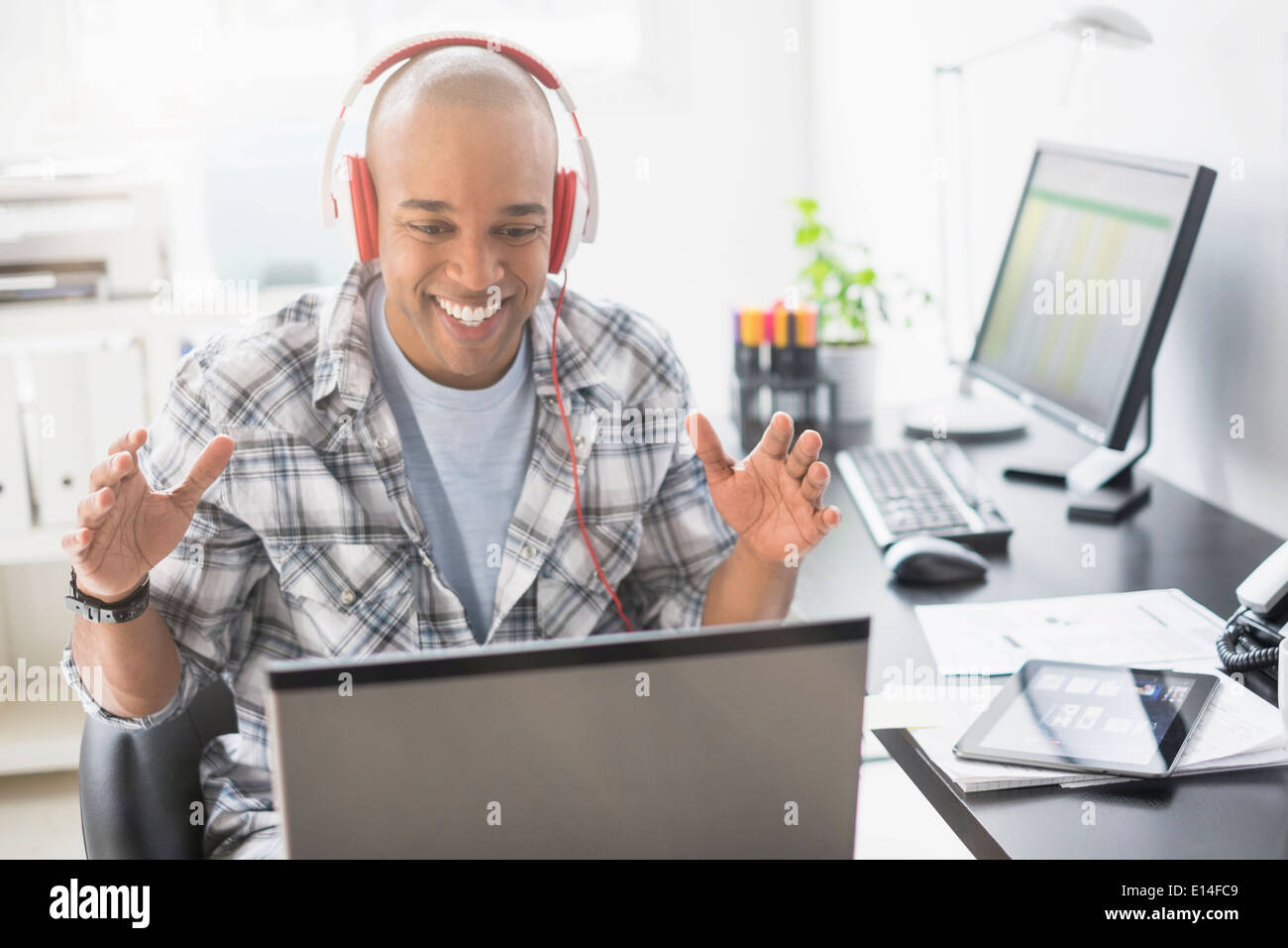 Schwarze Geschäftsmann hören Kopfhörer im Büro Stockfoto