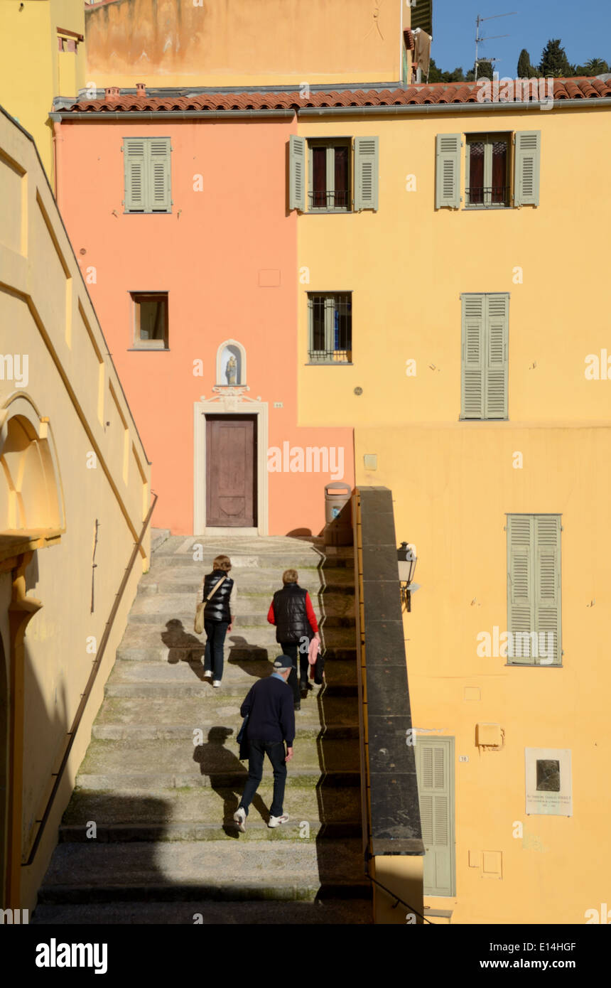 Touristen, die Treppenstufen, die Altstadt und gelb & Orange Glücksdorf Häuser Menton Alpes-Marittimes Frankreich Stockfoto