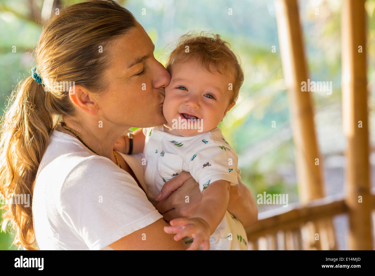 Kaukasische Mutter Babys Wange küssen Stockfoto