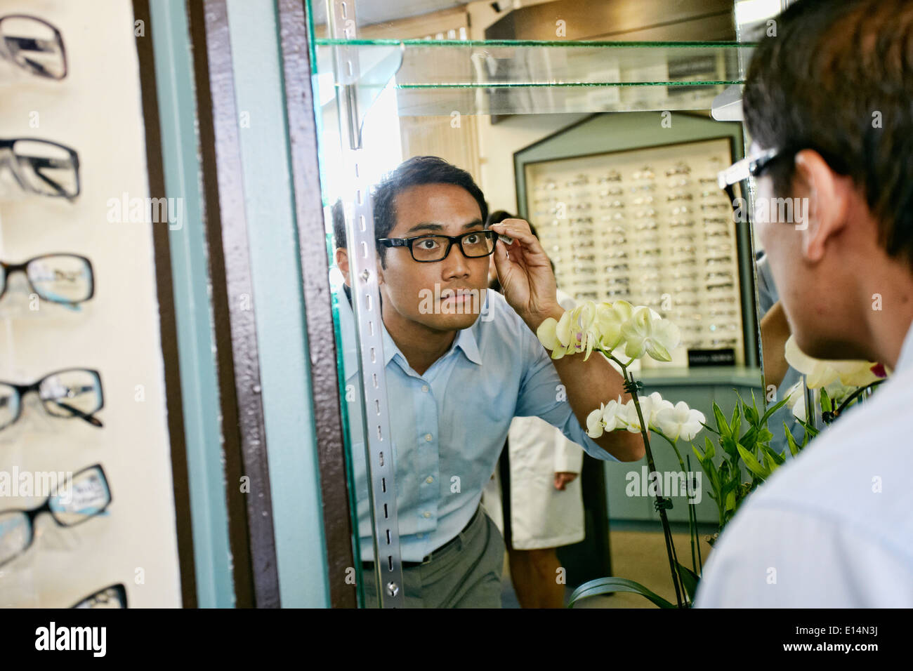 Philippinischen Mann versucht auf Gläser beim Optiker Stockfoto