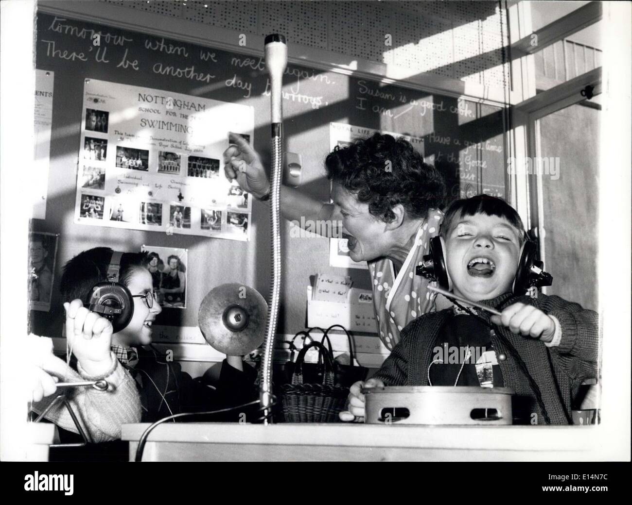 5. April 2012 - '' Es wird ein weiterer Tag morgen...'' und wenn es darum, diese taub geht werden Kinder immer noch so glücklich, wie sie jetzt im Musikunterricht sind, wenn die Geräusche eines Datensatzes an die Ohren über Kopfhörer übertragen werden. Mit ihnen ist Lehrerin Dorothy Marriott. Rechts ist unser Freund Anita Taylor, acht. Stockfoto