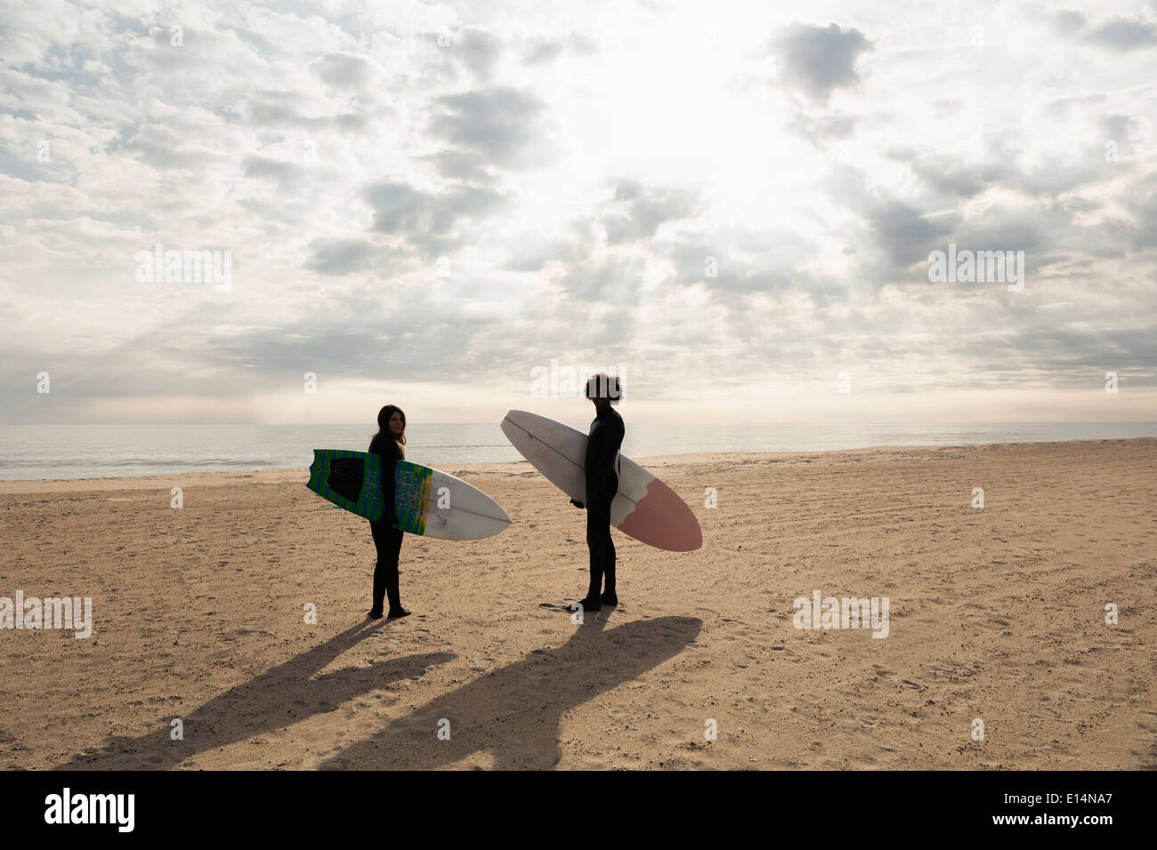 Surfer, die Bretter am Strand tragen Stockfoto
