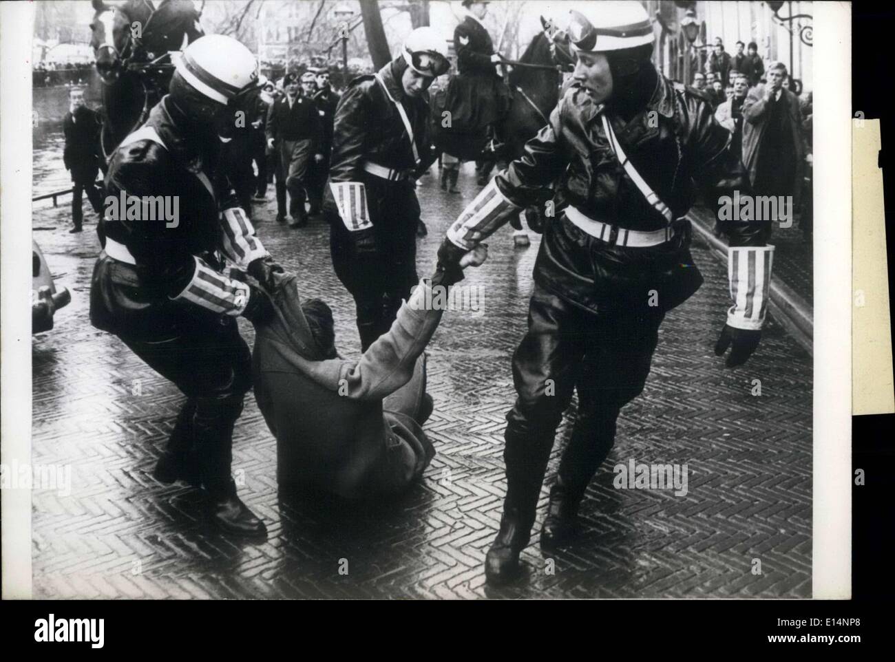 9. April 2012 - gestern gab es Vorfälle während der Braut Teil des königlichen Brautpaares, Prinzessin Beatrix der Niederlande und Prinz Claus Von Amsberg, durch die Straßen von Amsterdam vorbeiging. Die Demonstranten wurden von der Polizei mit Tränengas aufgelöst. Einige wurden gewaltsam festgenommen. Hier ist ein Bild von ein Demonstrant, indem er sich Drogen entlang von zwei Polizisten zu sein. Stockfoto