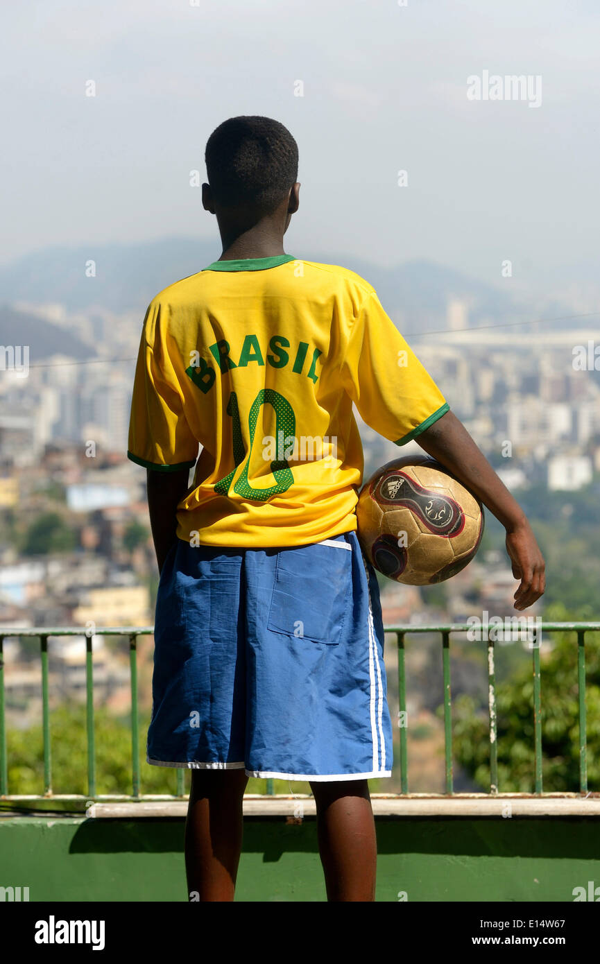 Junge hält einen Fußball-jungen und ein Brasilien-Trikot mit Blick auf das Zentrum von Rio De Janeiro, Rio de Janeiro Zustand Stockfoto