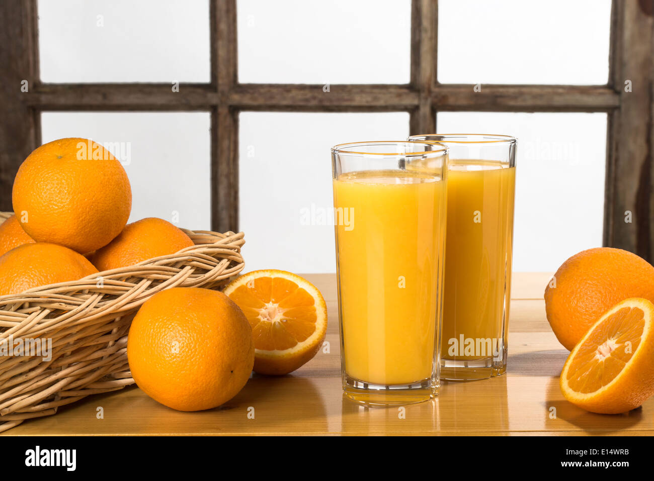 Orangensaft - zwei Gläser Orangensaft auf Tisch mit Orangen Stockfoto