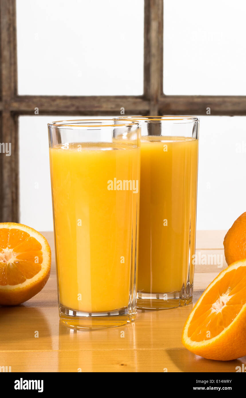 Orangensaft - zwei Gläser Orangensaft auf Tisch mit Orangen Stockfoto