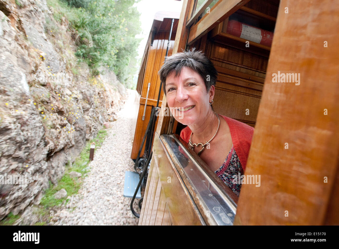 Ein Frau Passagier schaut aus hölzernen Nostalgiezug auf seiner Route durch die Serra de Tramuntana zwischen Sóller und Palma Stockfoto