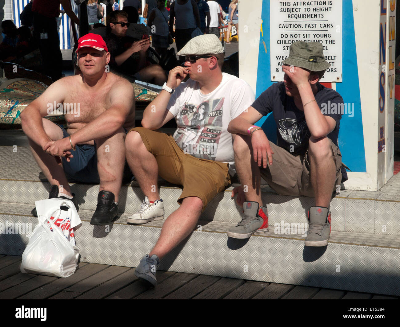 Drei Freunde sitzen für eine Rast am Pier von Brighton Stockfoto