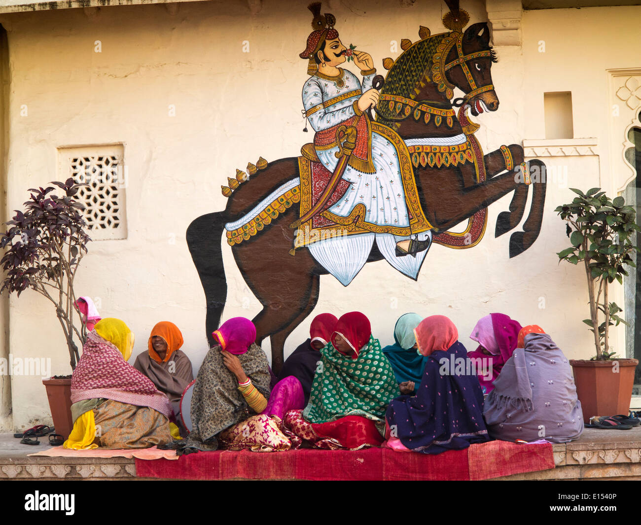 N9572 Indien, Rajasthan, Udaipur, Stadtschloss, Rajasthani Frauen Sänger unter Wandmalerei der Maharaja auf Pferd Stockfoto