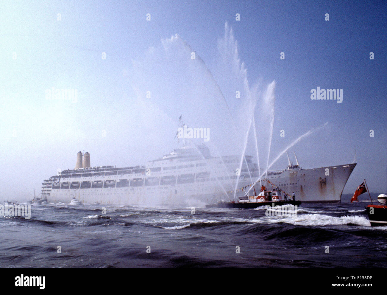 AJAXNETPHOTO. 11. MASCHINENBAUTAG, 1982. -WAL KEHRT - S.S.CANBERRA, UMLAUFZEITEN VON MOD ZU DIENEN ALS ATROOPSHIP WÄHREND DES FALKLAND-KONFLIKT KEHRT NACH SOUTHAMPTON, BEGLEITET DURCH EINE RIESIGE FLOTTE VON GÖNNERN UND EINE FIREFLOAT.  FOTO: JONATHAN EASTLAND/AJAX.  REF: CD 21103 1 04.HD LIN CAN Stockfoto