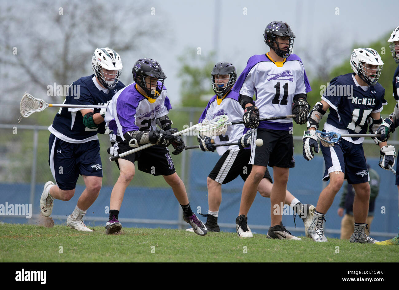 Texas High School Boy Lacrosse Action mit LBJ High School (lila) vs. Round Rock McNeil (dunkelblau). Stockfoto