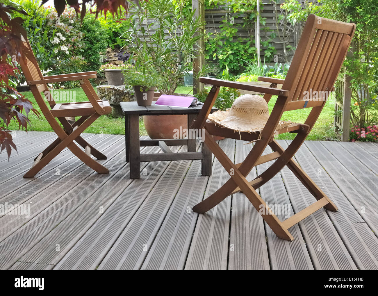 Stühle und Tisch auf Holzterrasse im Garten Stockfoto